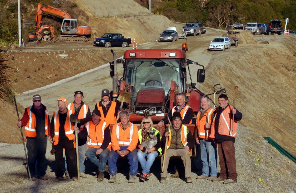 Some of the community volunteers who helped build a new section of Haven St behind them which...