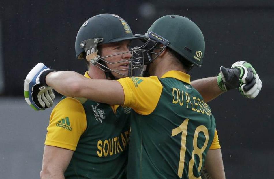 South Africa's AB de Villiers (L) and Faf du Plessis celebrate their 100 run partnership during...