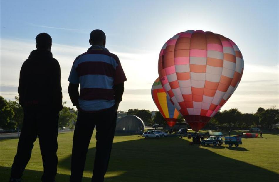 Spectators watch as colourful balloons are inflated in Oamaru's  Awamoa Park yesterday morning...