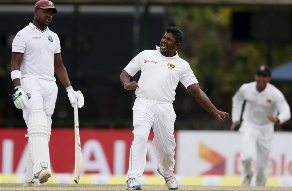 Sri Lanka's Rangana Herath (C) celebrates after taking the wicket of West Indies' Denesh Ramdin ...