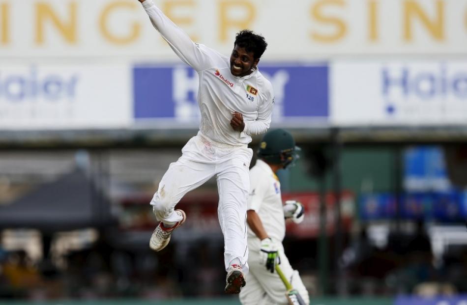 Sri Lanka's Tharindu Kaushal celebrates after taking the wicket of Pakistan's Yasir Shah (behind...