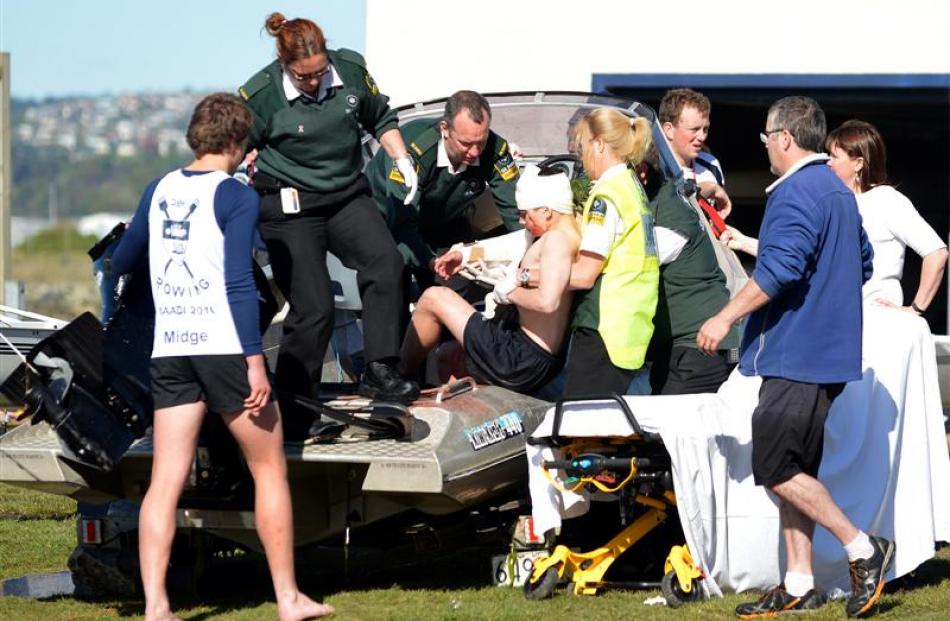 St John paramedics treat an injured boy at the scene after a powerboat smashed into the side of a...