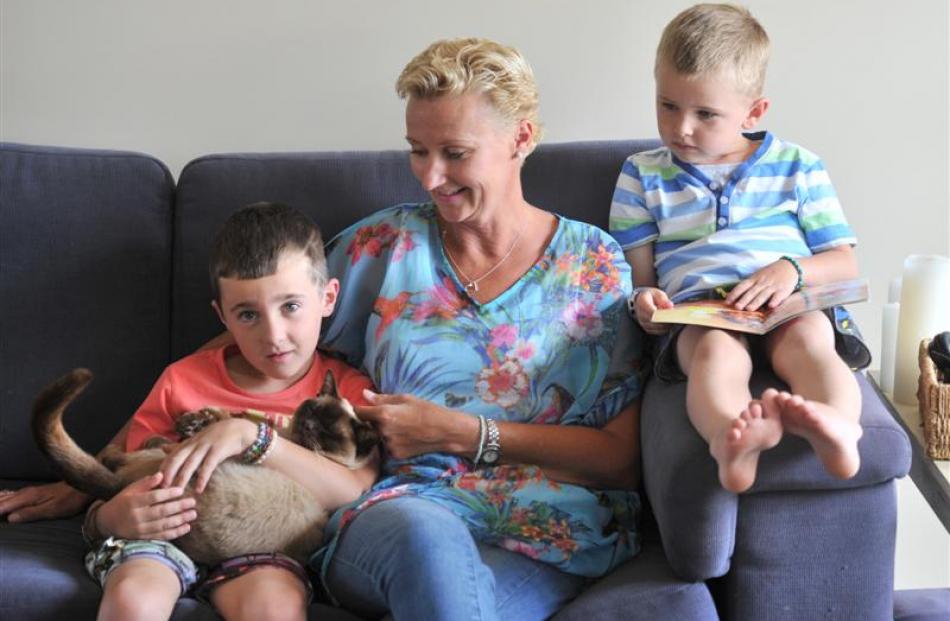 Stacey Jefferies, who had a mastectomy a year ago, with sons Cole, holding Coco the cat, and...