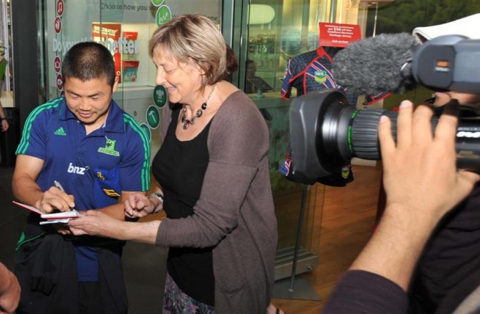 Highlanders halfback Fumiaki Tanaka signs an autograph for a fan at the Wall Street mall last...