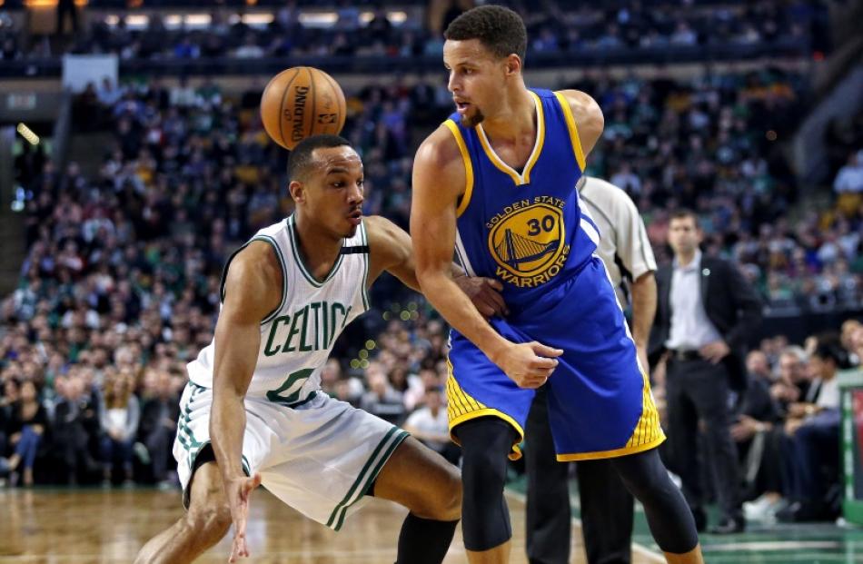 Steph Curry passes behind his back as Celtics guard Avery Bradley plays defence. Photo: Reuters