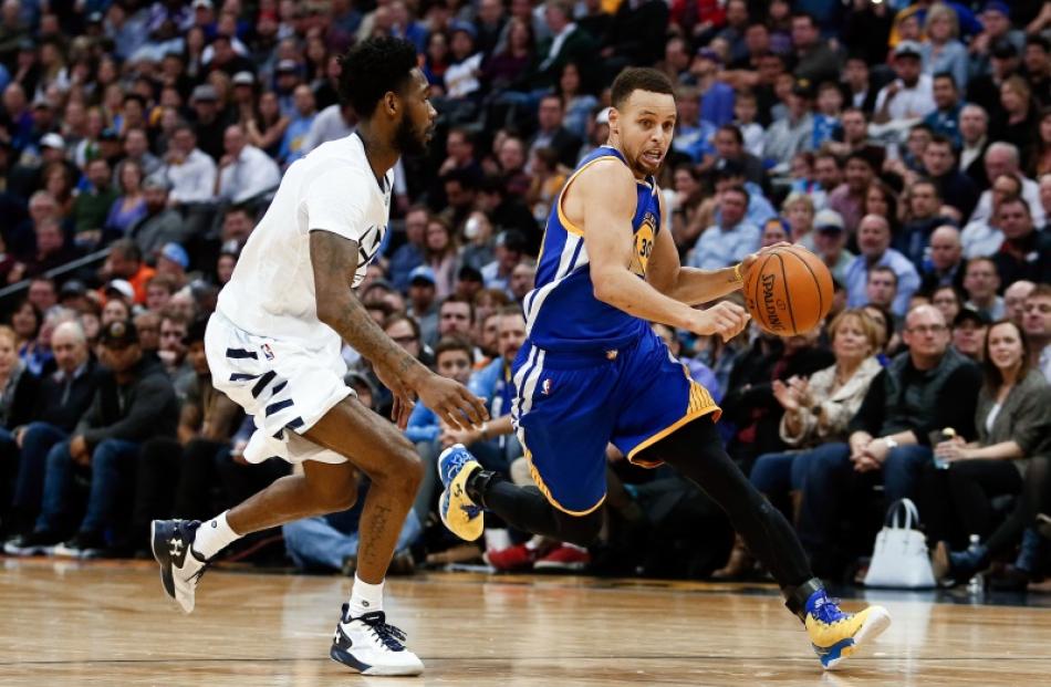 Stephen Curry drives to the hoop for the Golden State Warriors as Will Barton defends him. Photo:...
