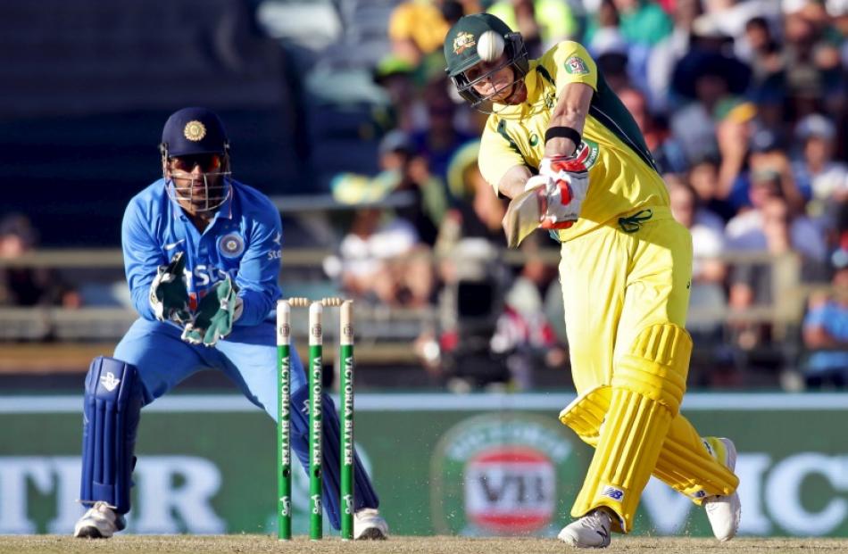 Steve Smith hits a six as MS Dhoni looks on. Photo: Reuters