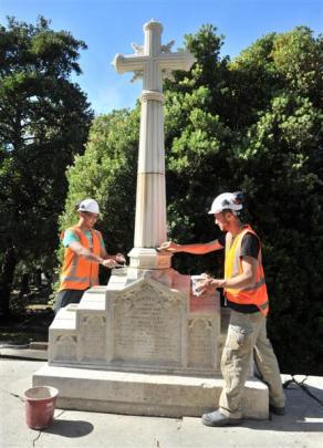 Stonemasons Wei Liu (left) and Marcus Wainwright clean up the new spire and cross installed by...