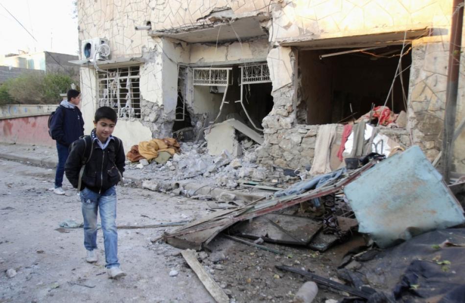 Students inspect a damaged house after a bomb attack in Kirkuk, 250km north of Baghdad.Photo by...