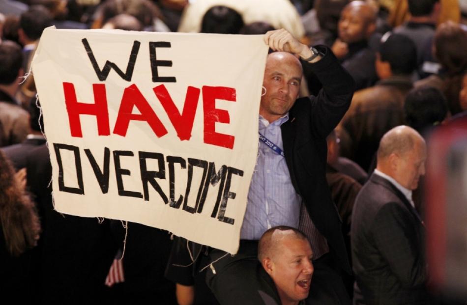 Supporters of U.S. President Barack Obama hold up a sign during his election night rally in...