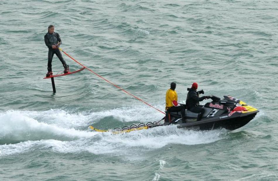 Surfing guru Titus Kinimaka has some fun on a hydrofoil surfboard towed behind a jet ski off Long...