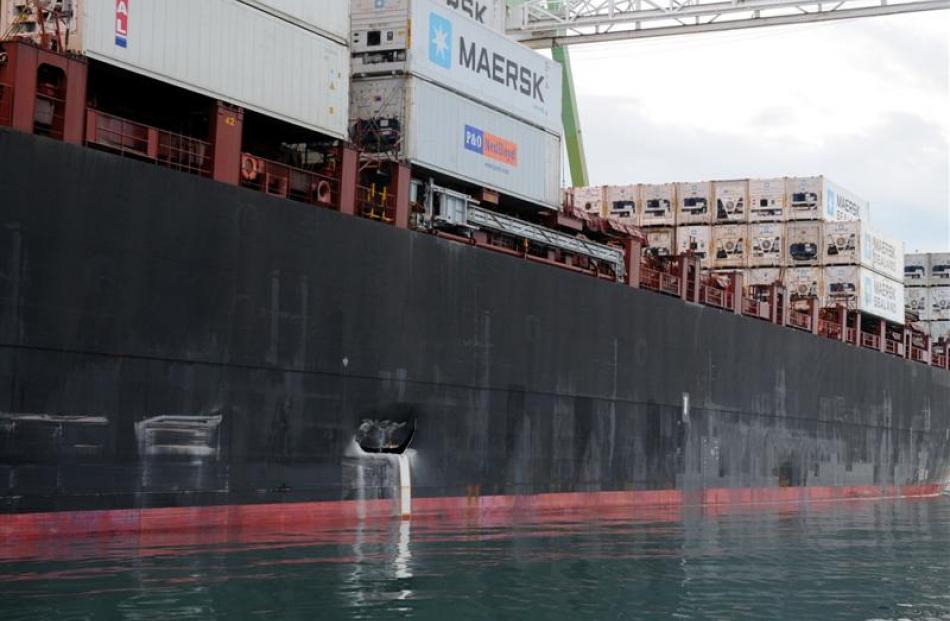 Survey engineers photograph damage to the Maersk Dabou container ship,  caused when it struck the...