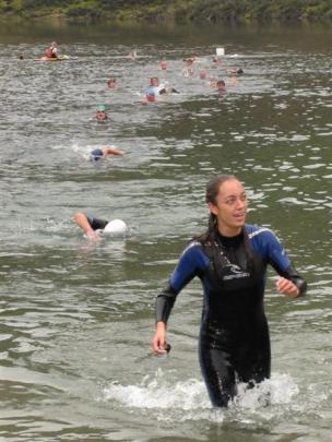Swimmer Danielle Gibson (17) emerges from the lake after the first stage of the  triathlon....