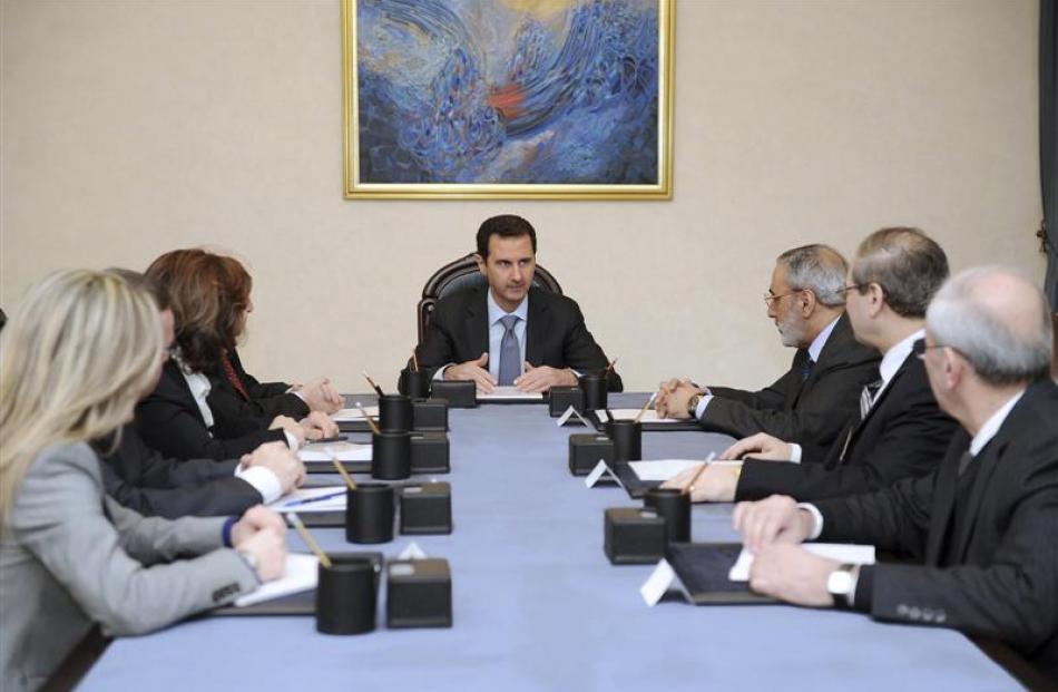 Syria's President Bashar al-Assad (centre) meets the official delegation tasked with...