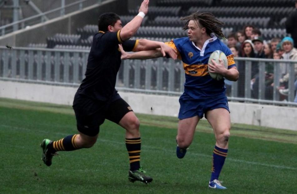 Taieri winger Shannon Young fends off Dunedin hooker Sam Anderson-Heather.