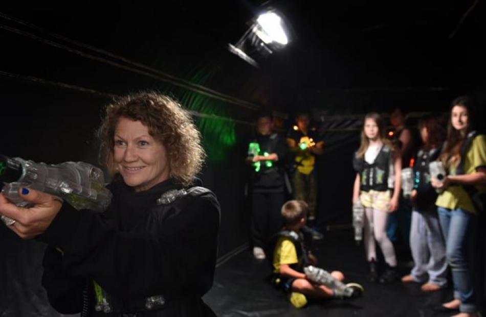 Tarn Felton aims her laser in a Megazone game tent at the Caversham  MoveMe event at Carisbrook...