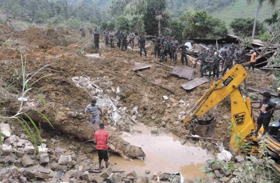 Teams engage in rescue operation work at the site of a landslide at the Koslanda tea plantation...