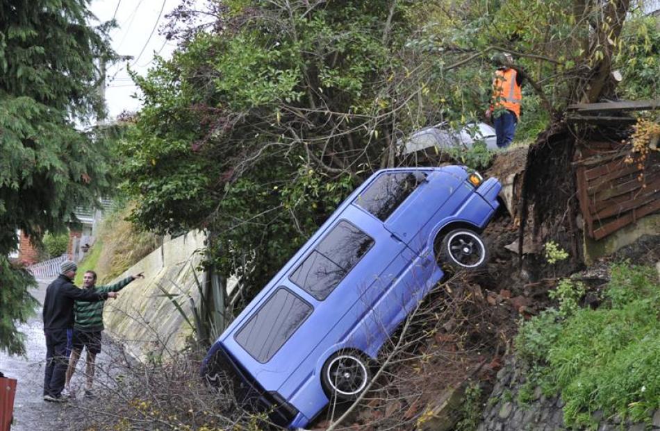 Tenant Craig Joyce (right) and house owner Adam Hill discuss the salvage of a van after a...