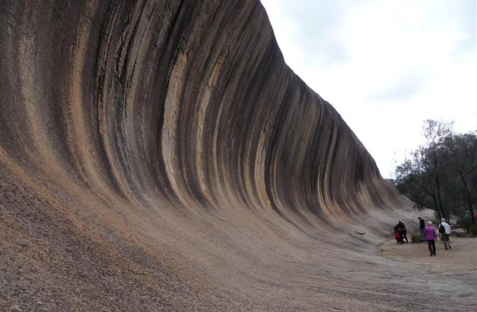 The 15m high Wave Rock towers over visitors in the central wheatbelt region of Western Australia....