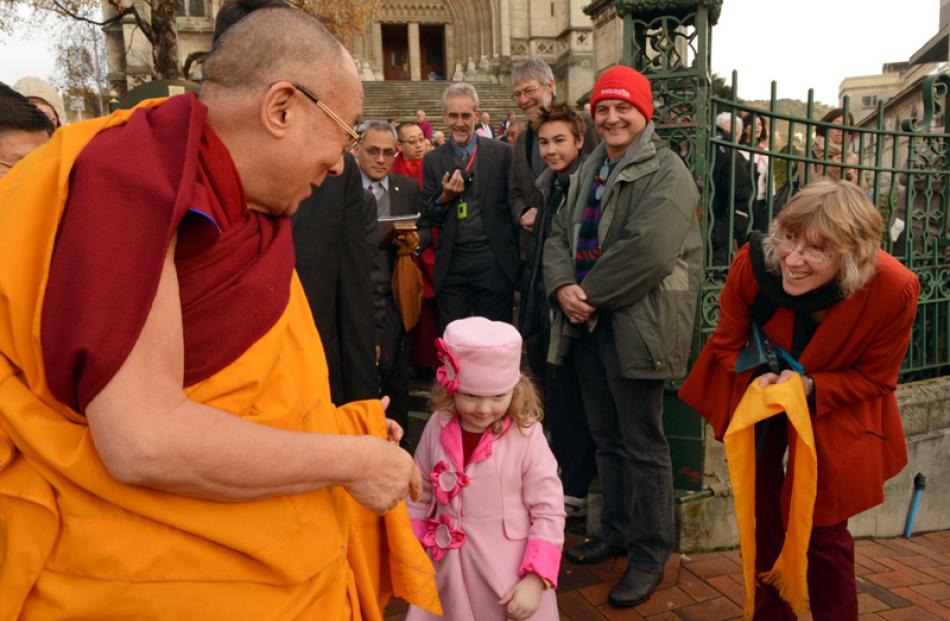 The Dalai Lama greets a young girl in front of St Paul's Cathedral.