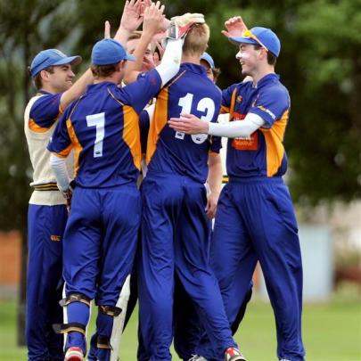 The excited bowler, Jack Hunter (shirt No 13), celebrates with his team-mates. Photos by Craig...