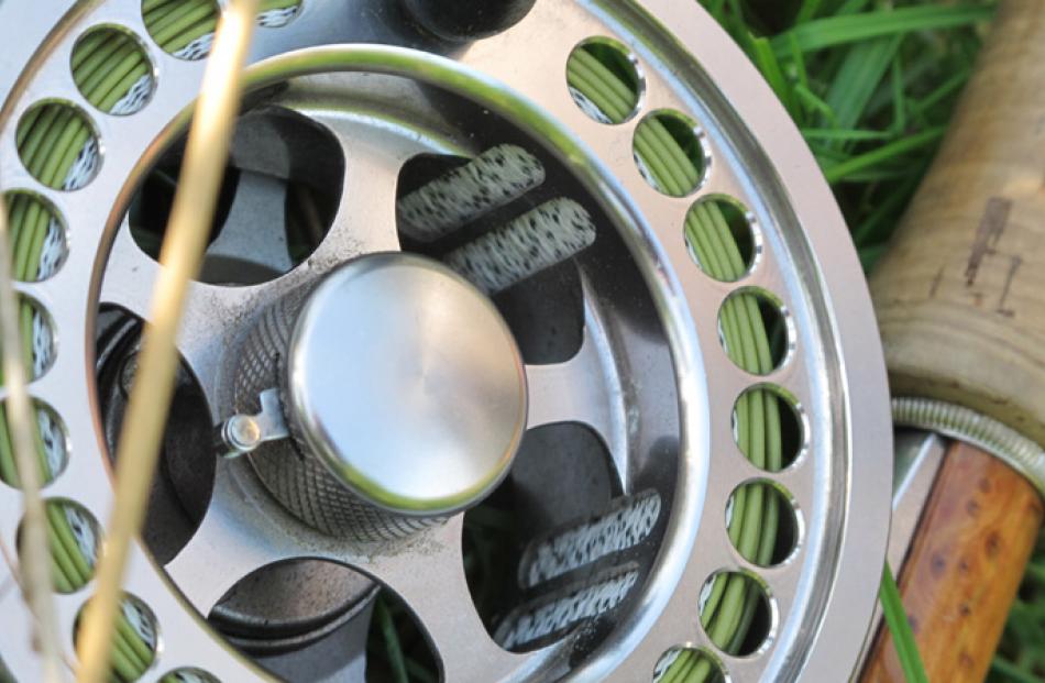 The hardware ... Fly reel on the river bank.