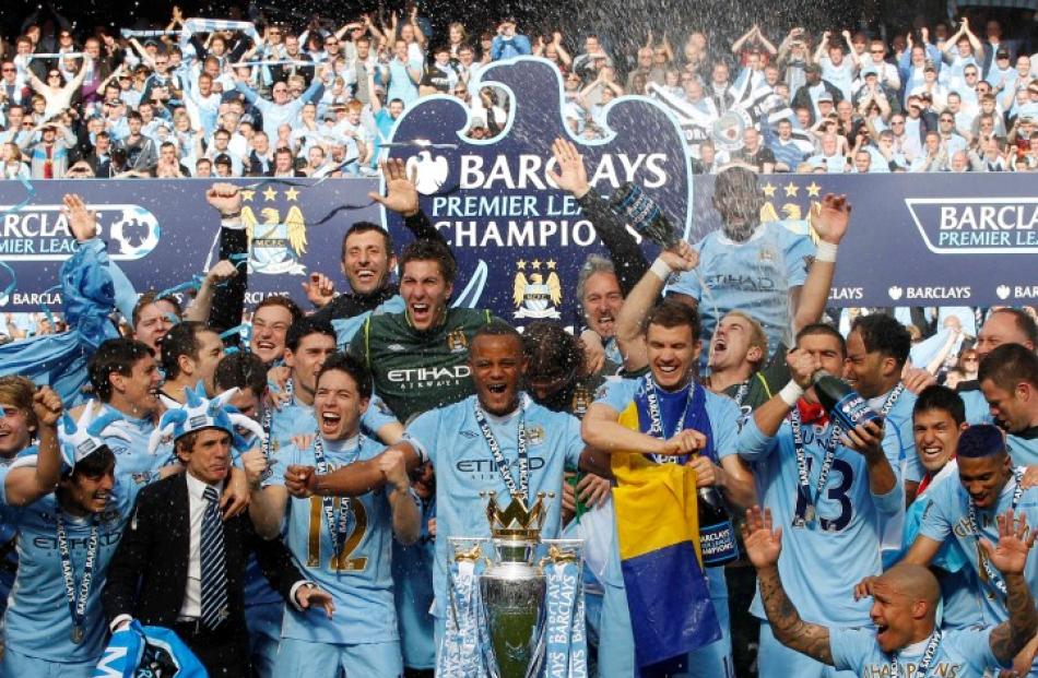 The Manchester City team celebrate winning the English Premier League following their match...