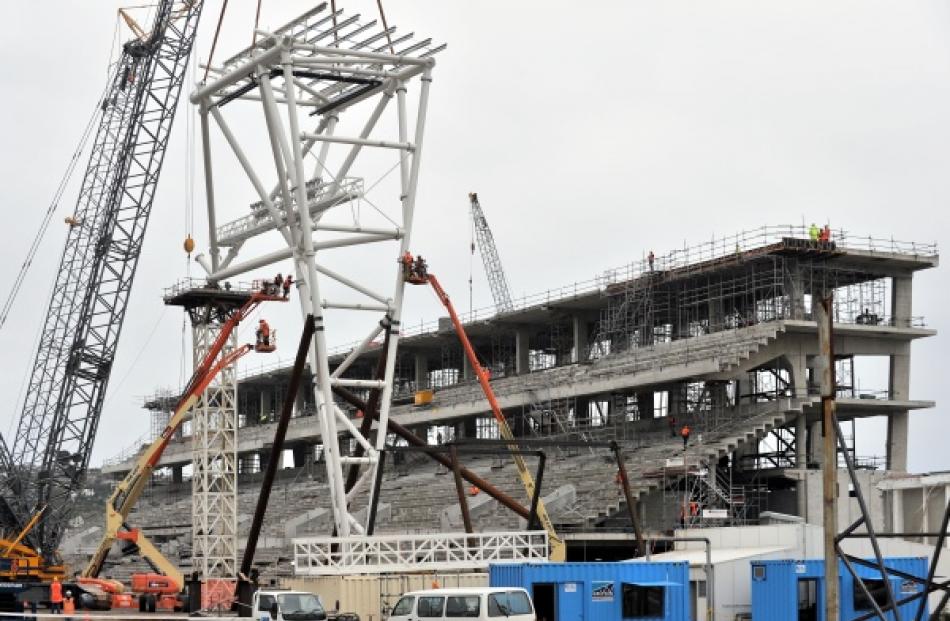 The roof column topped by a piece of steel truss is taking shape at the stadium site.