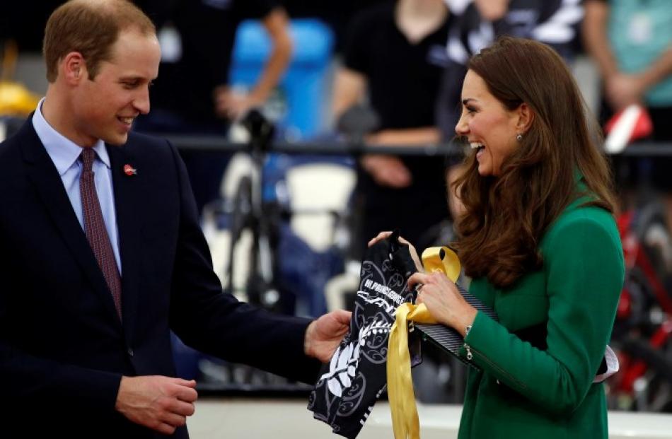 The royal couple share a laugh after being presented with a cycling jersey for their son, Prince...