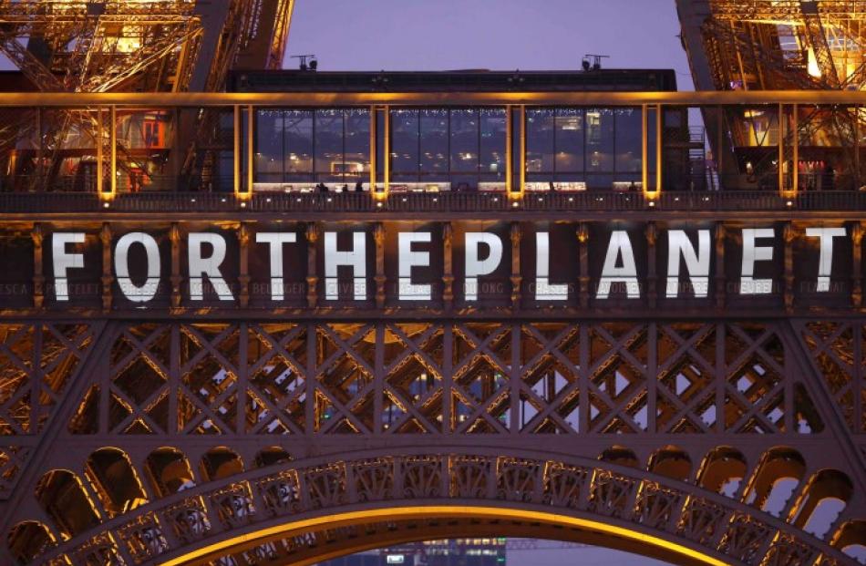 The slogan 'For the planet' is projected on the Eiffel Tower as part of the World Climate Change...
