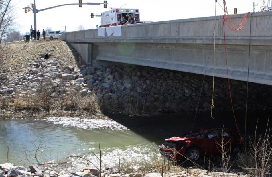 The wreckage of the car that Lily Groesbeck was saved from sits on an embankment underneath a...