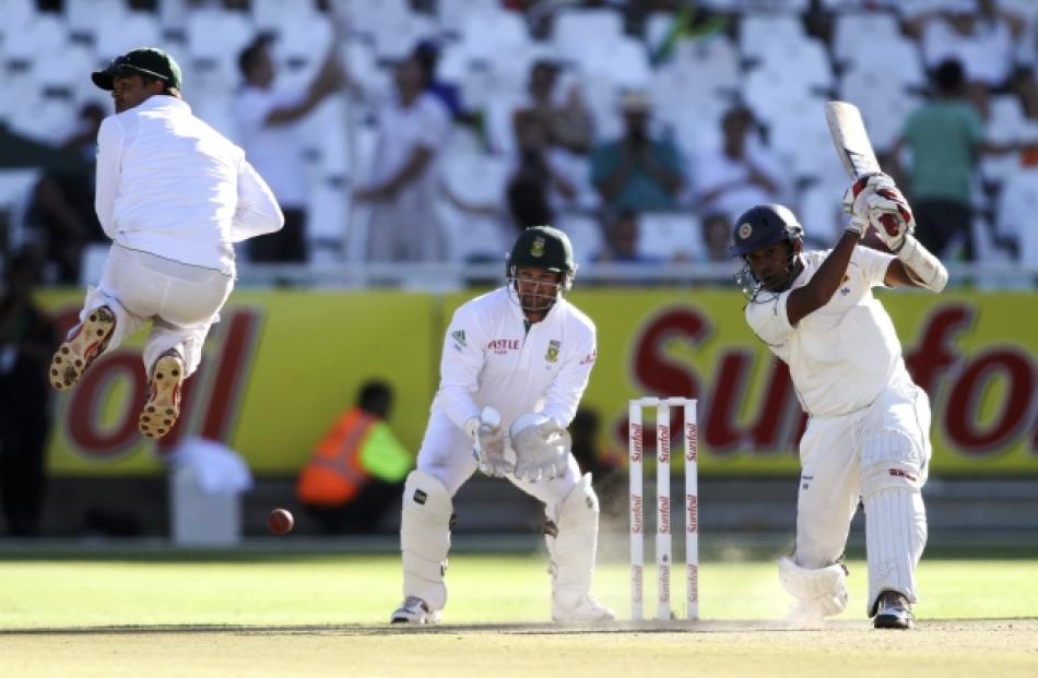 Thilan Samaraweera of Sri Lanka drives a delivery as Jacques Rudolph of South Africa takes...