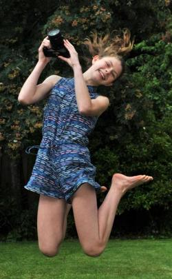 This year's winner, Madeline Bilkey, jumps for joy while holding the Canon EOS 7000 DSLR camera...