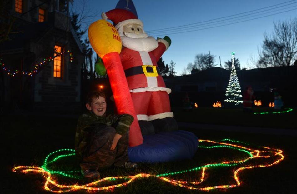 Thomas Dunn (9), of Middlemarch, sits by Santa outside St John's Presbyterian Church during the...