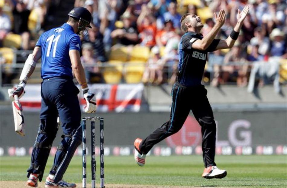 Tim Southee (R) celebrates after dismissing England's Steven Finn during their Cricket World Cup...