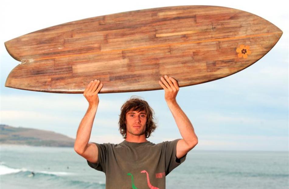 Tom Leckie with his surfboard made of flax stalks, at St Clair last night. Photo by Gregor...