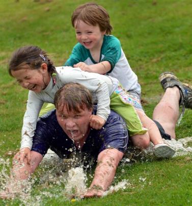 Tony Harris slides down the waterslide with his children Brodie (4) and Elle (6).