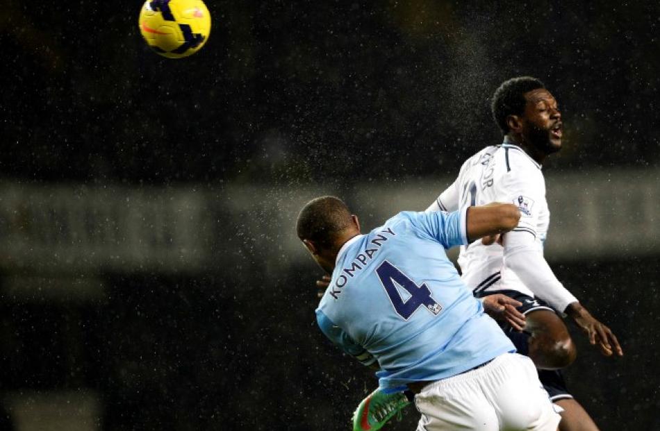 Tottenham Hotspur's Emmanuel Adebayor (R) is challenged by Manchester City's Vincent Kompany....