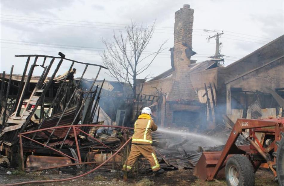 Tuatapere Volunteer Fire Brigade deputy chief fire officer Graeme Egerton dampens down hot spots...