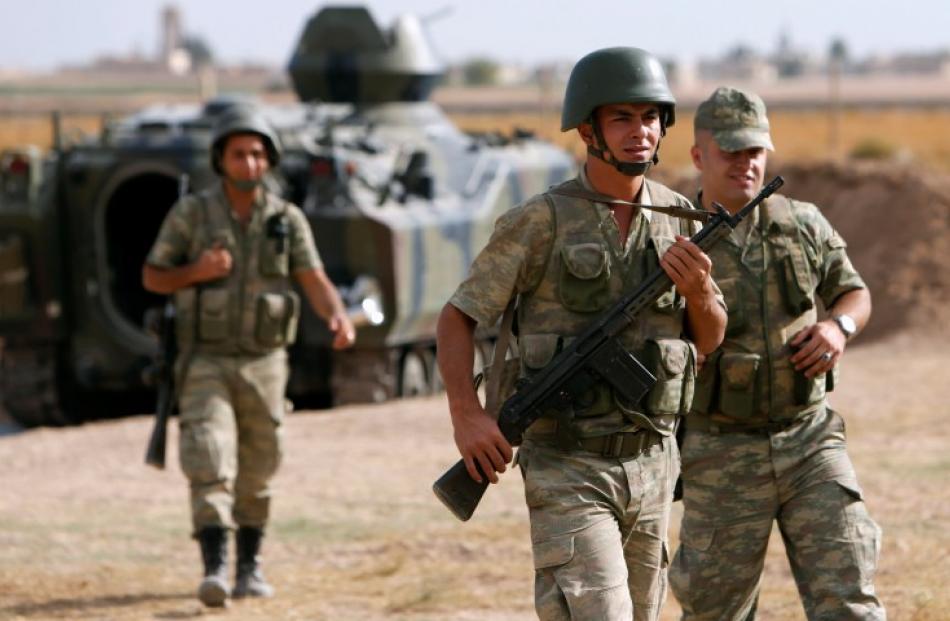 Turkish soldiers guard the Turkish-Syrian border near the Akcakale border crossing, southern...