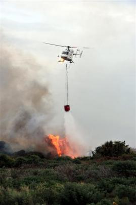 Two helicopters with monsoon buckets fought a raging vegetation fire yesterday evening. Photos by...