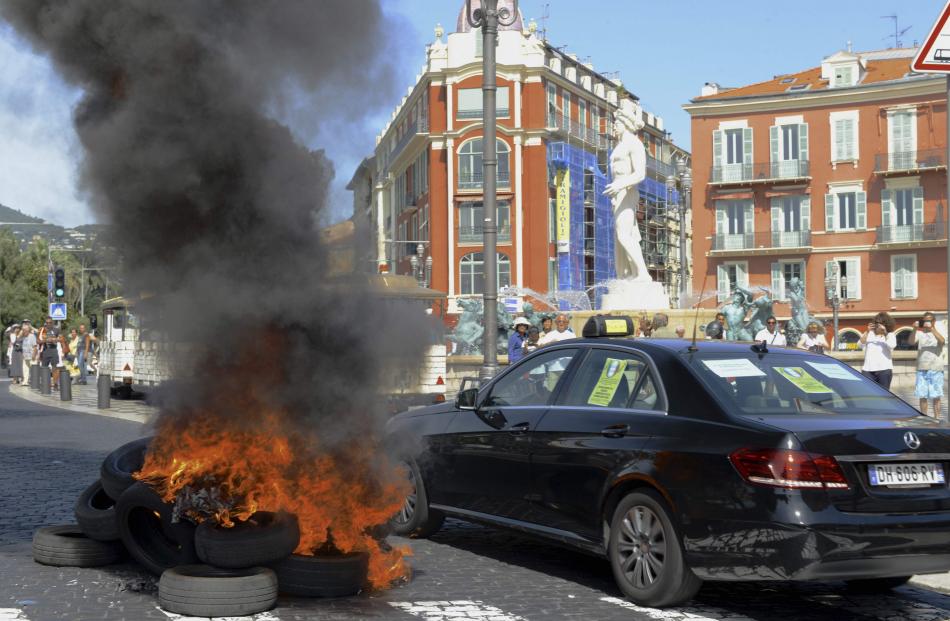 Tyres burn on the road in Nice as part of the national protest by taxi drivers. Photo: Reuters