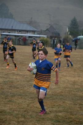 U11 Taieri's Hamish Faulks (11) sprints for the try line while being chased by Upper Clutha Black.