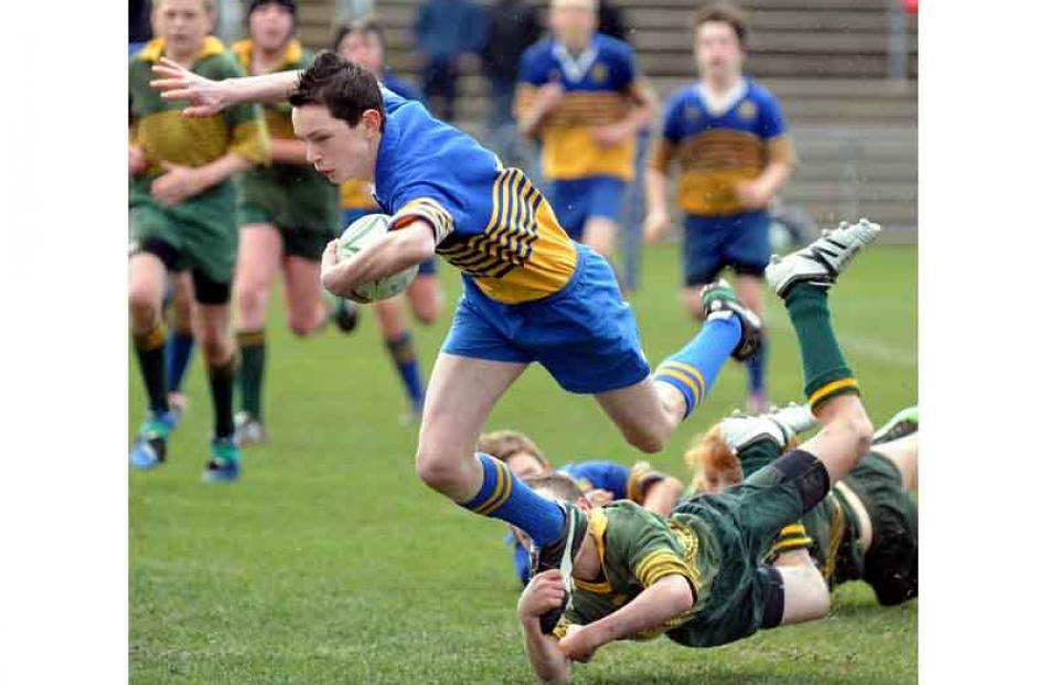 Lewis Kelly of Taieri with the ball is tackled by Mikaire Schooner of Eastern in the under 13...