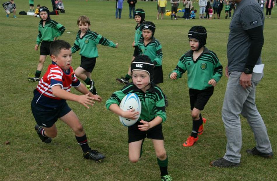 Under 8 Cromwell Red player moves in for the tackle Baxter Dimond (7) on  Under 8 Alexandra Black...