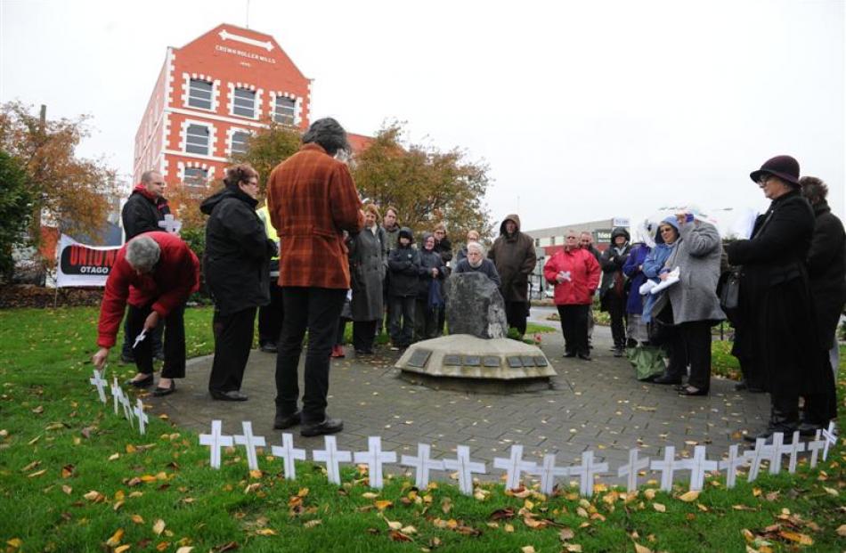 Unions Otago secretary Malcolm Deans (front left) reads a list of people who have died recently...