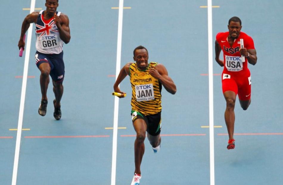 Usain Bolt of Jamaica (C) sprints to the finish line ahead of Dwain Chambers of Britain (L) and...