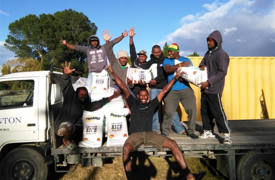 Vanuatuan men employed at Hinton's Orchard with rice their employer donated for the relief effort...