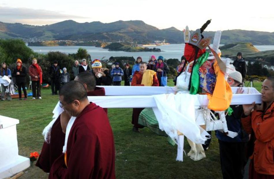Venerable Jampa Thupten Tulku Rinpoche is carried to the cremation stupa yesterday.