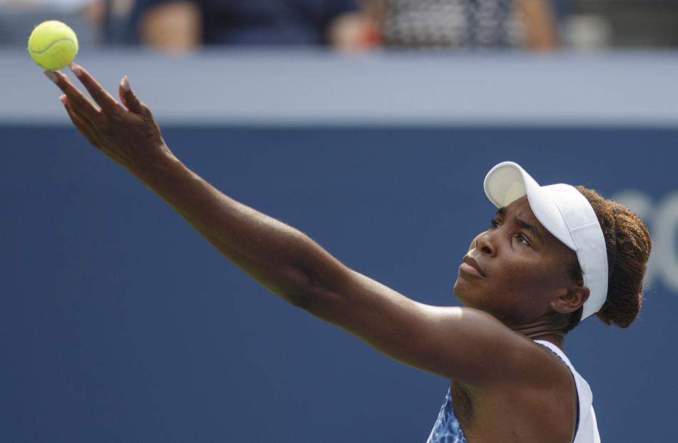 Venus Williams serves to Monica Puig during their first round match at the US Open. Photo: Reuters.